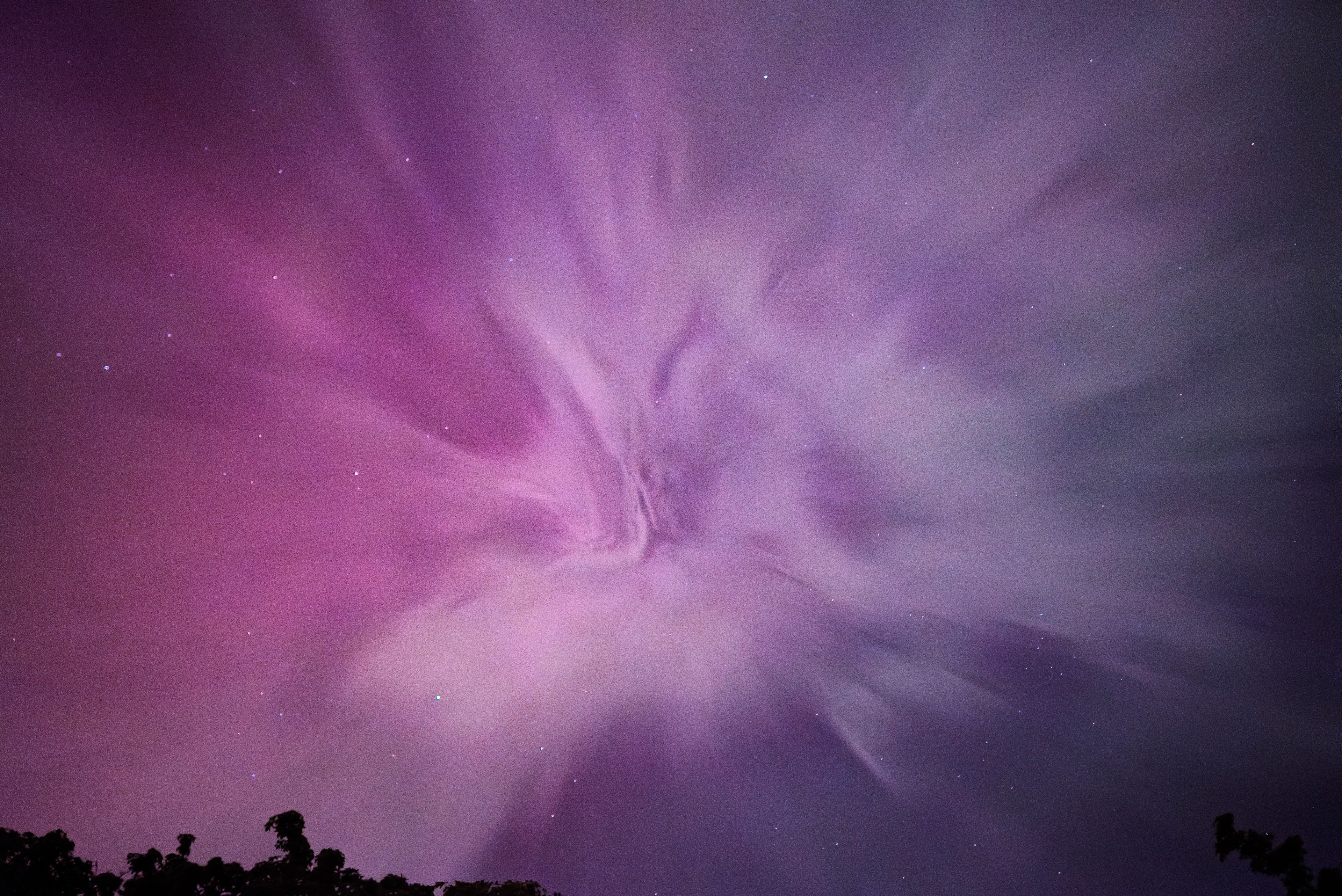 Clouds and distant stars rendered in purple and pink night light.